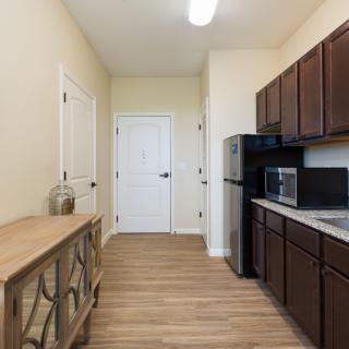 A modern kitchen with dark wood cabinets and stainless steel appliances.
