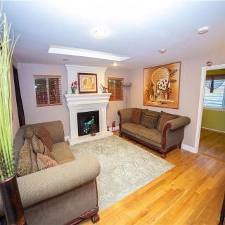 A cozy living room with two sofas, a fireplace, and artwork on the walls.