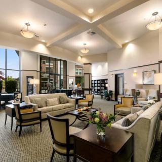 A spacious and elegantly designed living room with luxurious furniture and high ceilings.