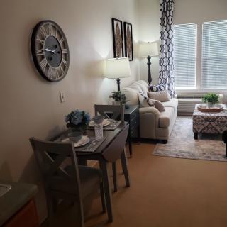 A cozy living room with a stylish sofa, dining table, and decorative elements.
