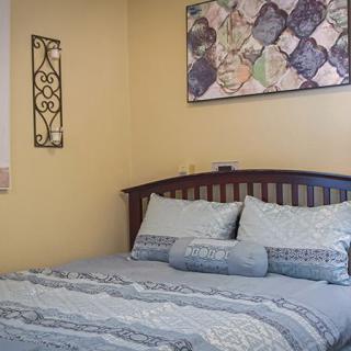A cozy bedroom with neatly arranged bedding and wall decor.