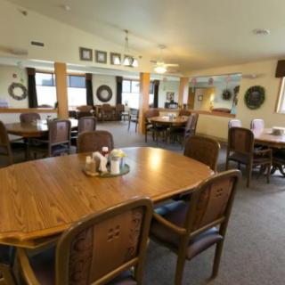 A spacious and well-lit dining room with multiple tables and chairs arranged for seating.