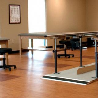 A spacious rehabilitation room equipped with parallel bars for physical therapy exercises.