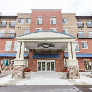 A modern commercial building with a prominent entrance and brick facade.