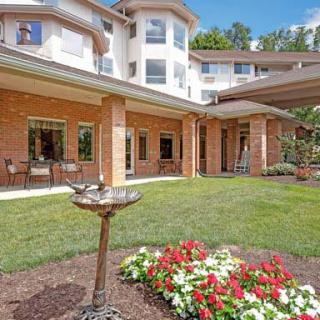 A well-maintained garden with colorful flowers in front of a multi-story residential building.