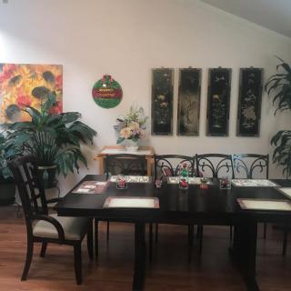 A well-decorated dining room with a large table, chairs, and artwork on the walls.