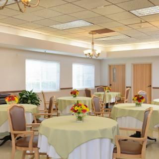 A cozy dining area with round tables, each adorned with floral centerpieces.
