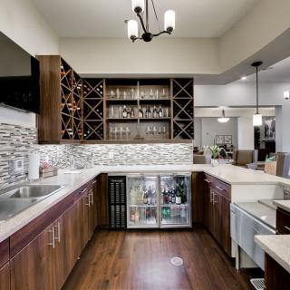 Modern kitchen with a wine rack and bar area featuring wood flooring and contemporary design.