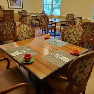 A cozy dining area with elegantly set tables ready for guests.