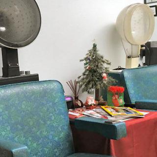 A cozy hair salon waiting area with vintage hair dryers and magazines.