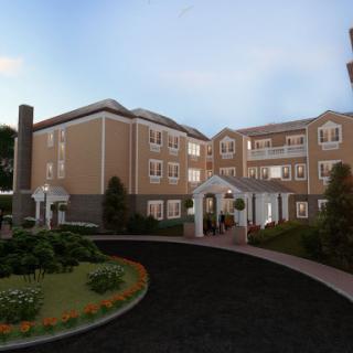 A modern residential building surrounded by well-maintained gardens and pathways.