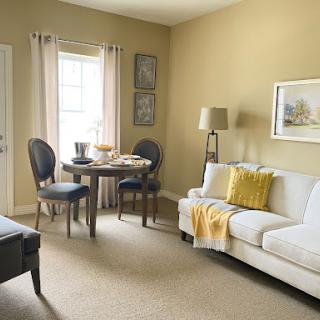 A cozy living space featuring a dining area and comfortable seating, accented with soft colors and natural light.