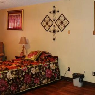A cozy bedroom with floral bedding and decorative wall art.