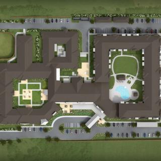 Aerial view of a complex with buildings, pool, and surrounding green spaces.