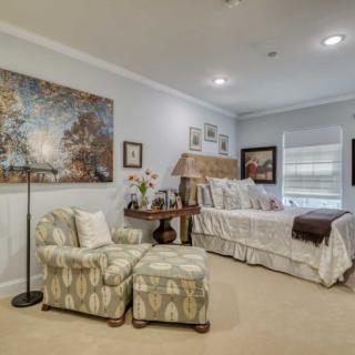 A cozy bedroom with elegant furnishings and artwork on the walls.