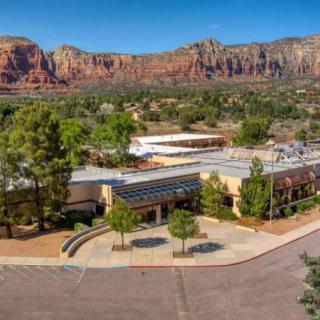 A building surrounded by trees with a backdrop of stunning desert mountains.
