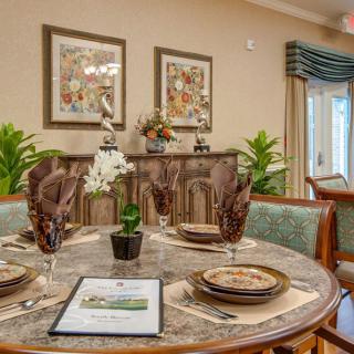 A beautifully set dining table with elegant decor and artwork in a cozy dining room setting.