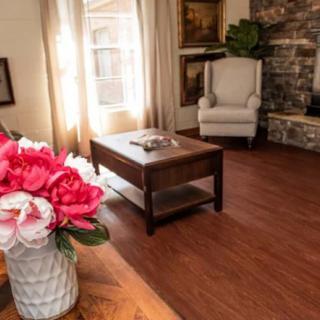 A cozy living room with a coffee table, armchair, and decorative flowers.