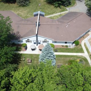 Aerial view of a spacious single-story home surrounded by lush greenery.