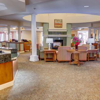 A spacious lobby interior featuring comfortable seating and a fireplace.