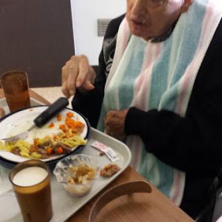 An elderly person enjoying a meal at a dining facility.