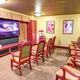 A cozy home theater setup with multiple chairs facing a large TV screen, surrounded by movie posters on the walls.