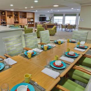A well-organized dining room with a neatly set table, adjacent to a cozy living area.