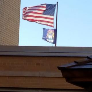 Flags of the United States and Michigan waving in the breeze.