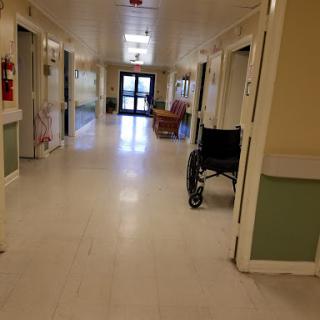 A view of a hospital hallway featuring a wheelchair.