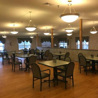 A spacious and well-lit dining area featuring tables and chairs, perfect for social gatherings.