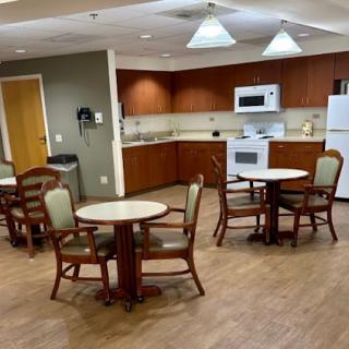 A cozy kitchen and dining area equipped with tables and chairs, featuring modern appliances.