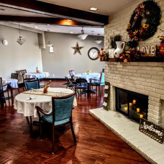 A cozy dining space with festive decorations and a warm fireplace.