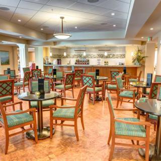 An empty restaurant dining area with neatly arranged tables and chairs.