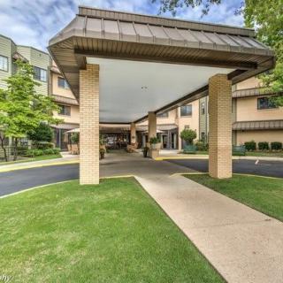 Covered entrance with a canopy leading to a building, surrounded by well-maintained landscaping.