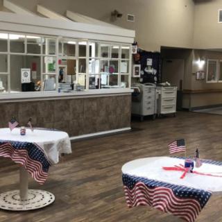 An interior of a community center with tables decorated in American flag-themed tablecloths.