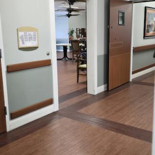 A view of a well-lit hallway in a healthcare facility, showcasing doors and an inviting atmosphere.