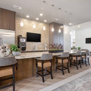 A modern kitchen featuring an island counter with bar stools and stylish pendant lighting.