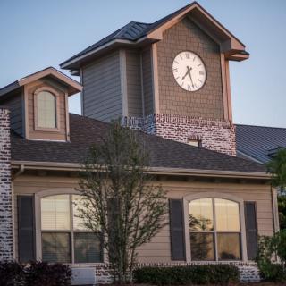 A house with a clock tower under the evening sky.