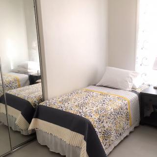 A minimalist bedroom with a single bed and large mirror.