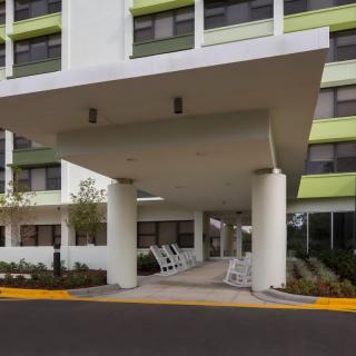 The entrance of a modern building with a canopy and large columns.
