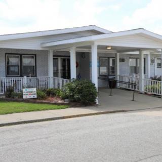 A residential building with a porch and ramp at the entrance.