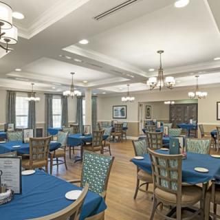 A well-lit dining area with blue tablecloths and elegant decor.