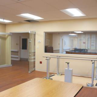 A rehabilitation therapy room with parallel bars and exercise equipment.