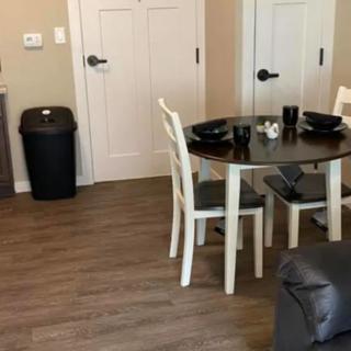 A cozy dining area with a round table and white chairs on a wooden floor.