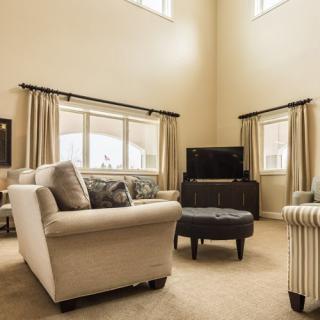 A spacious living room with comfortable seating and large windows.