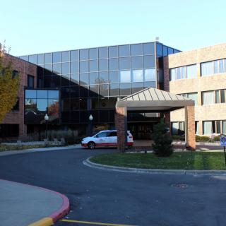A modern hospital building with a main entrance and large glass windows.