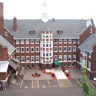 A large brick building with a central courtyard and numerous windows.