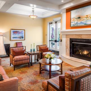 A cozy living room with a fireplace, comfortable seating, and warm decor.