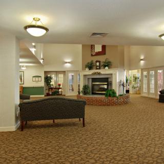 A spacious lobby featuring a central fireplace and comfortable seating arrangements.
