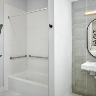 A modern and clean bathroom with a shower, bathtub, and sink area.